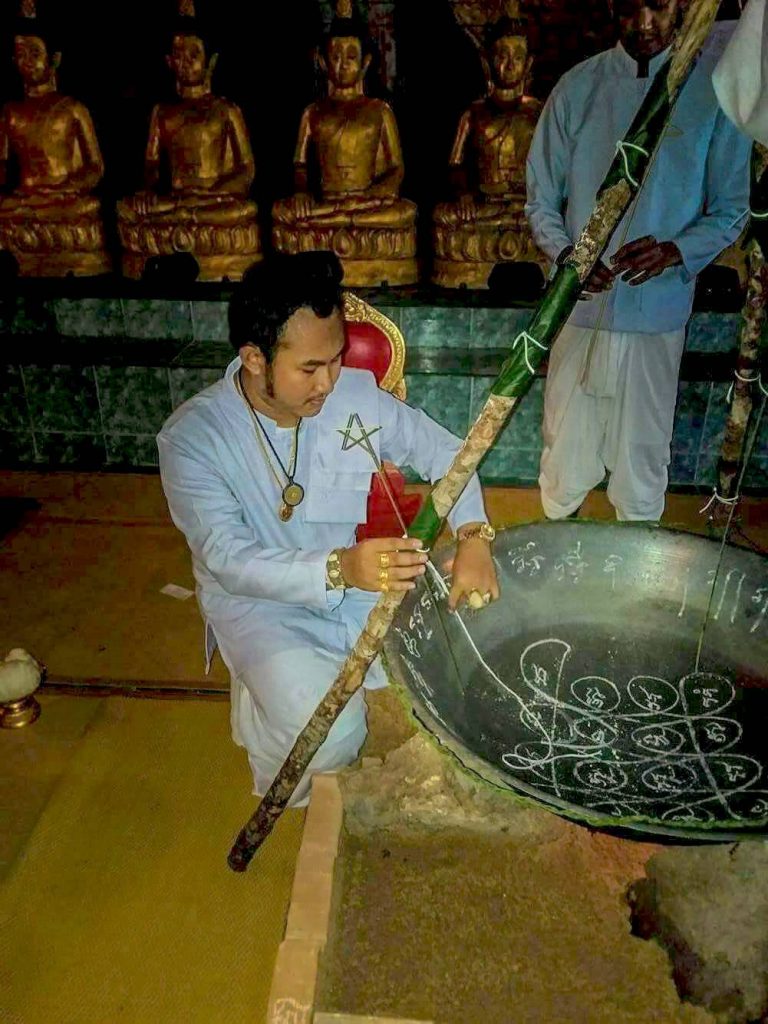 Ajarn Sitthichai Honbandit inscribes a talisman on the pan before cooking Namman Sorot.